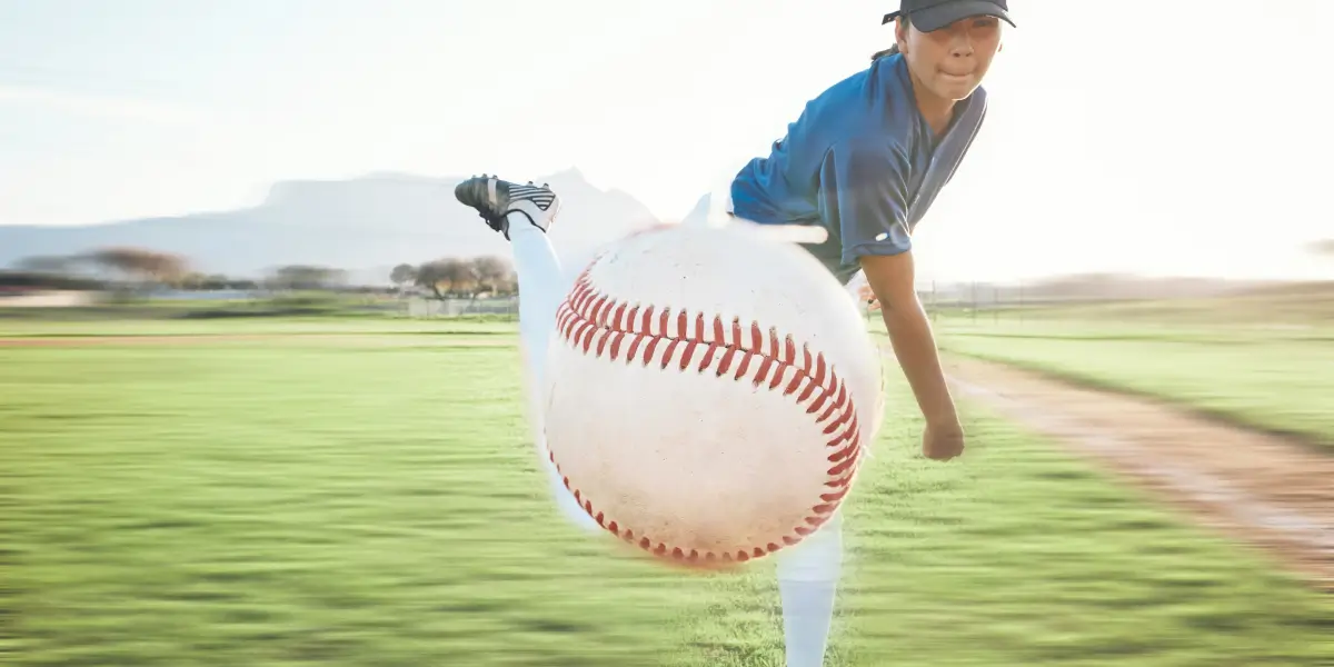 A young baseball player throws a baseball at the camera